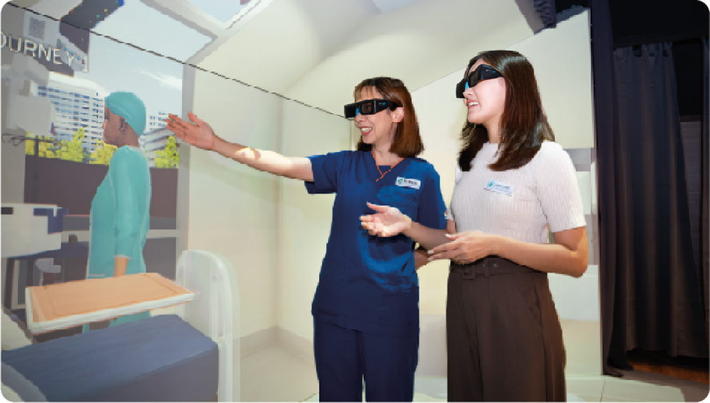 Two women wearing 3D glasses interact with a virtual hospital room.